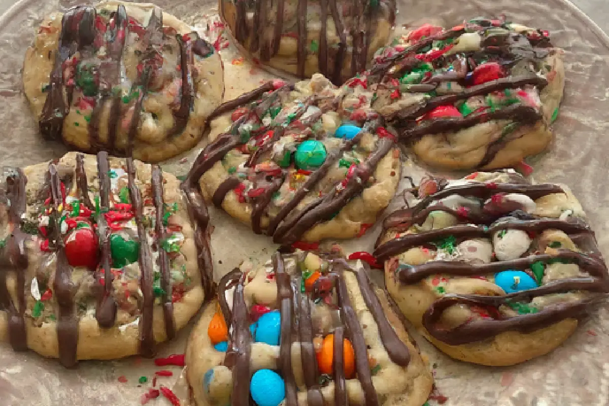 A close-up shot of several decorated Toll House cookies displayed on a plate. They are drizzled with melted chocolate, sprinkled with colorful candies, and have festive shapes.