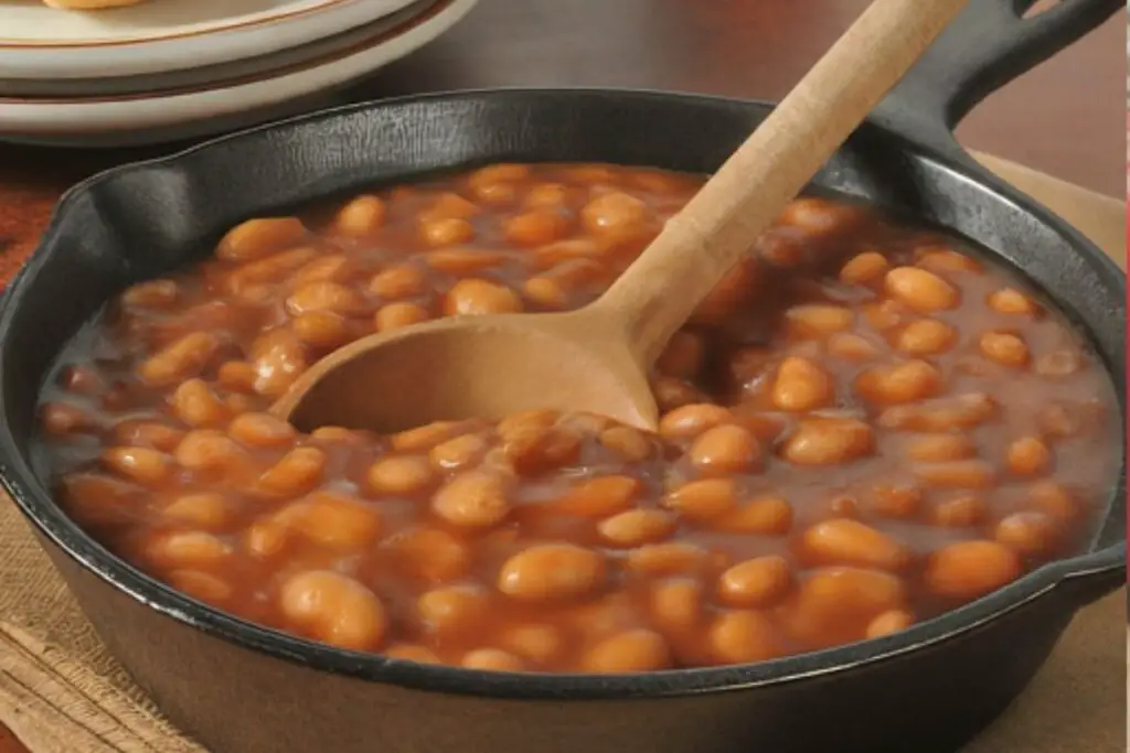 A cast iron skillet overflowing with delicious baked beans, ready to be enjoyed